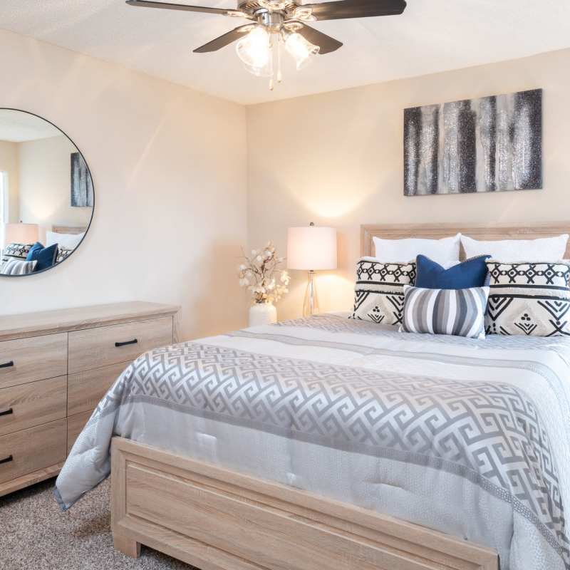 Charming bedroom featuring a cozy bed adorned with stylish pillows and soft lighting at Charter Oak in Euless, Texas