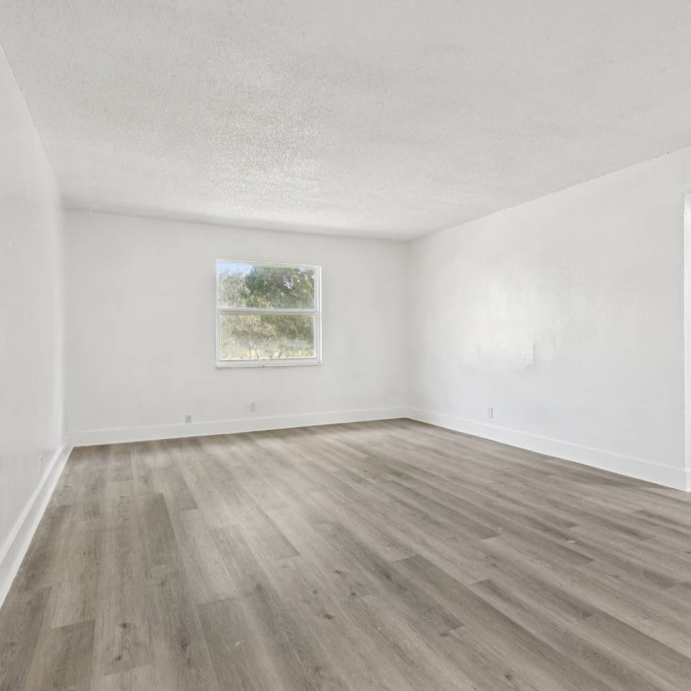 Living room space with wood style flooring at El Jardin Apartments in Hollywood, Florida