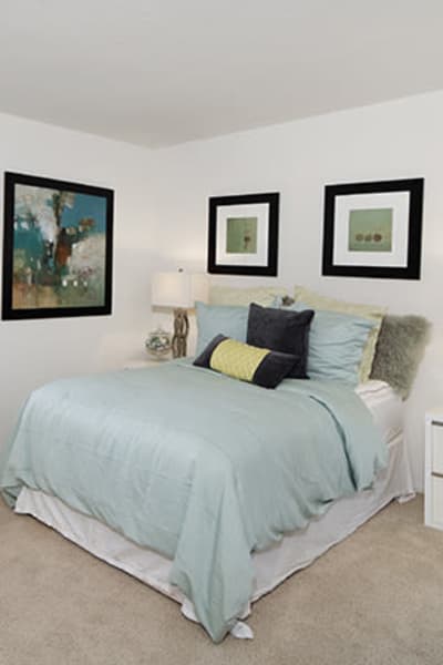 Model bedroom with white bedspread and two lamps at The Ranch at Moorpark, Moorpark, California