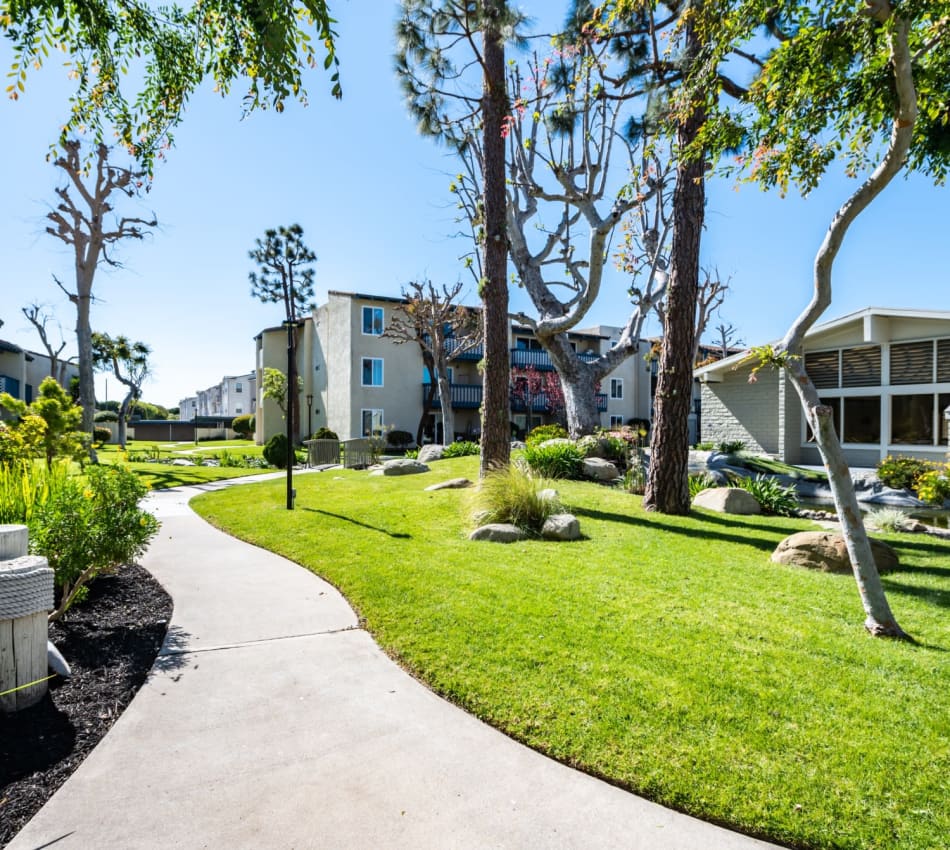 Luscious outdoor walkways with well kept landscaping and trees at The Landing at Channel Islands in Oxnard, California