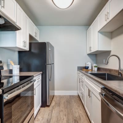 Modern kitchen with bright white appliances and cabinetry in a model home at Sofi Union City in Union City, California