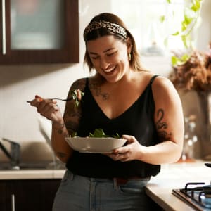 Resident having a quick bite in her fully-equipped kitchen at Parkway Villas in Grand Prairie, Texas