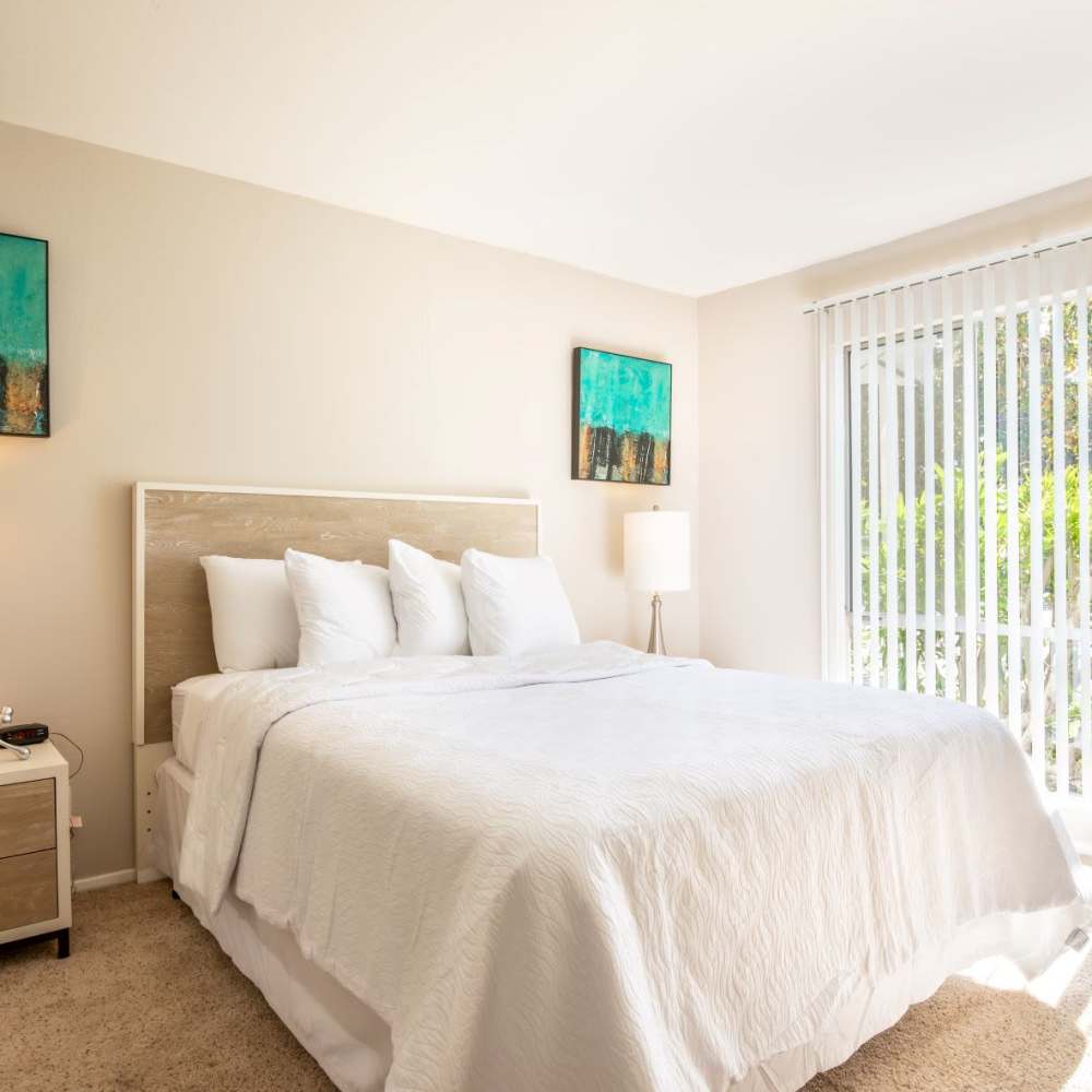 Bright bedroom with full height window at Glenwood Garden Apartments in Mountain View, California
