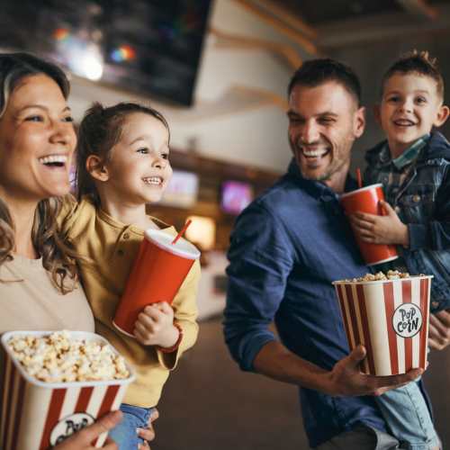 Family enjoying movie night with popcorn at Jefferson Manor Townhomes in Fairport, New York