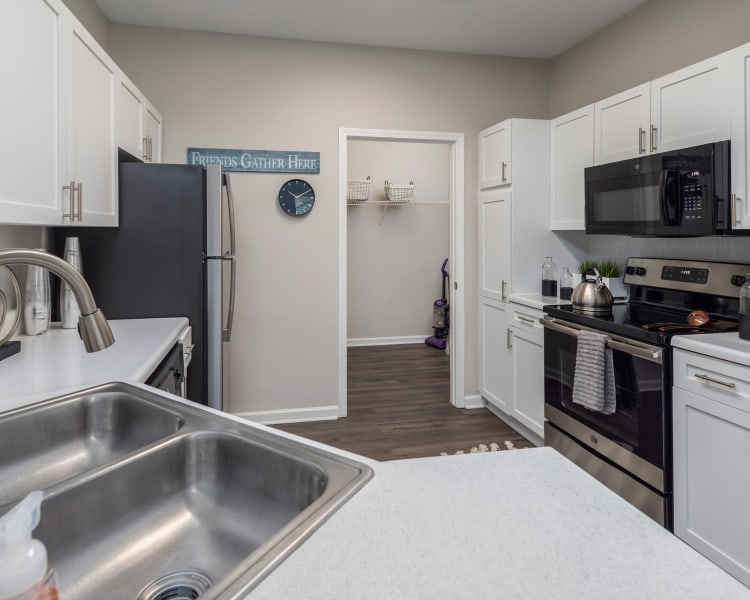 Model apartment's kitchen with stainless-steel appliances and white cabinetry at Highlands at Alexander Pointe in Charlotte, North Carolina