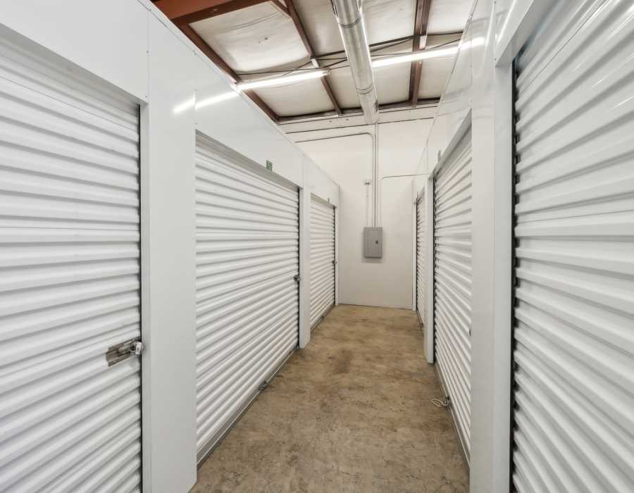 Clean, spacious storage unit hallway with secure roll-up doors at Storage Hub - Grissom in San Antonio, Texas