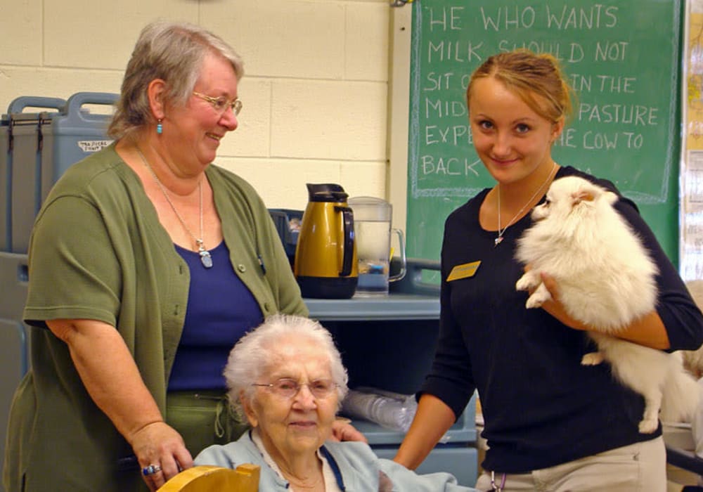 Resident enjoying time with a resident cat and staff at Montello Care Center in Montello, Wisconsin