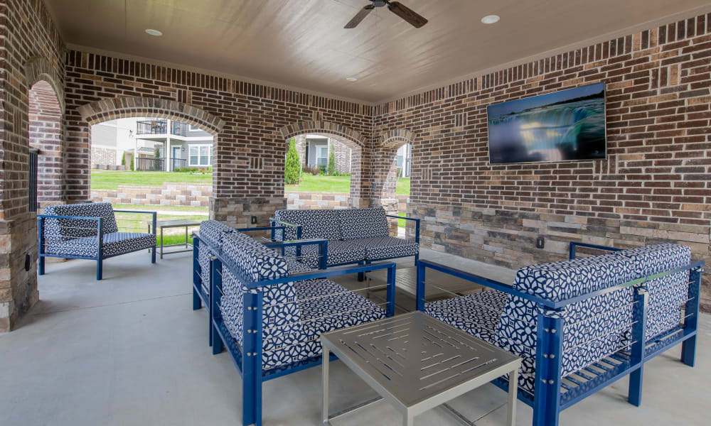 Covered lounge area with television near pool at Cottages at Crestview in Wichita, Kansas