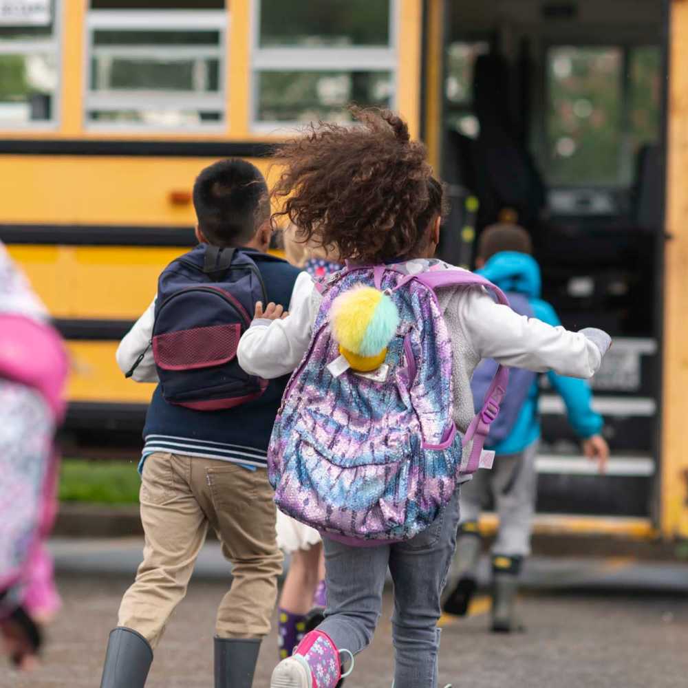 Resident child boarding bus near Sycamore Heights Townhomes in Tontitown, Arkansas