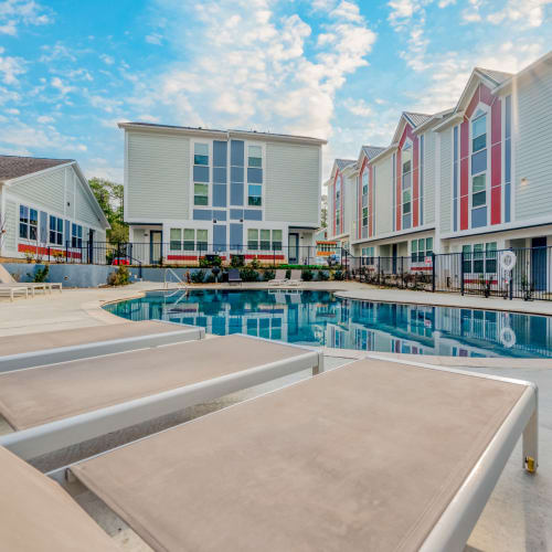 Lounge chairs by the pool at Huntsville Village Apartments in Huntsville, Texas