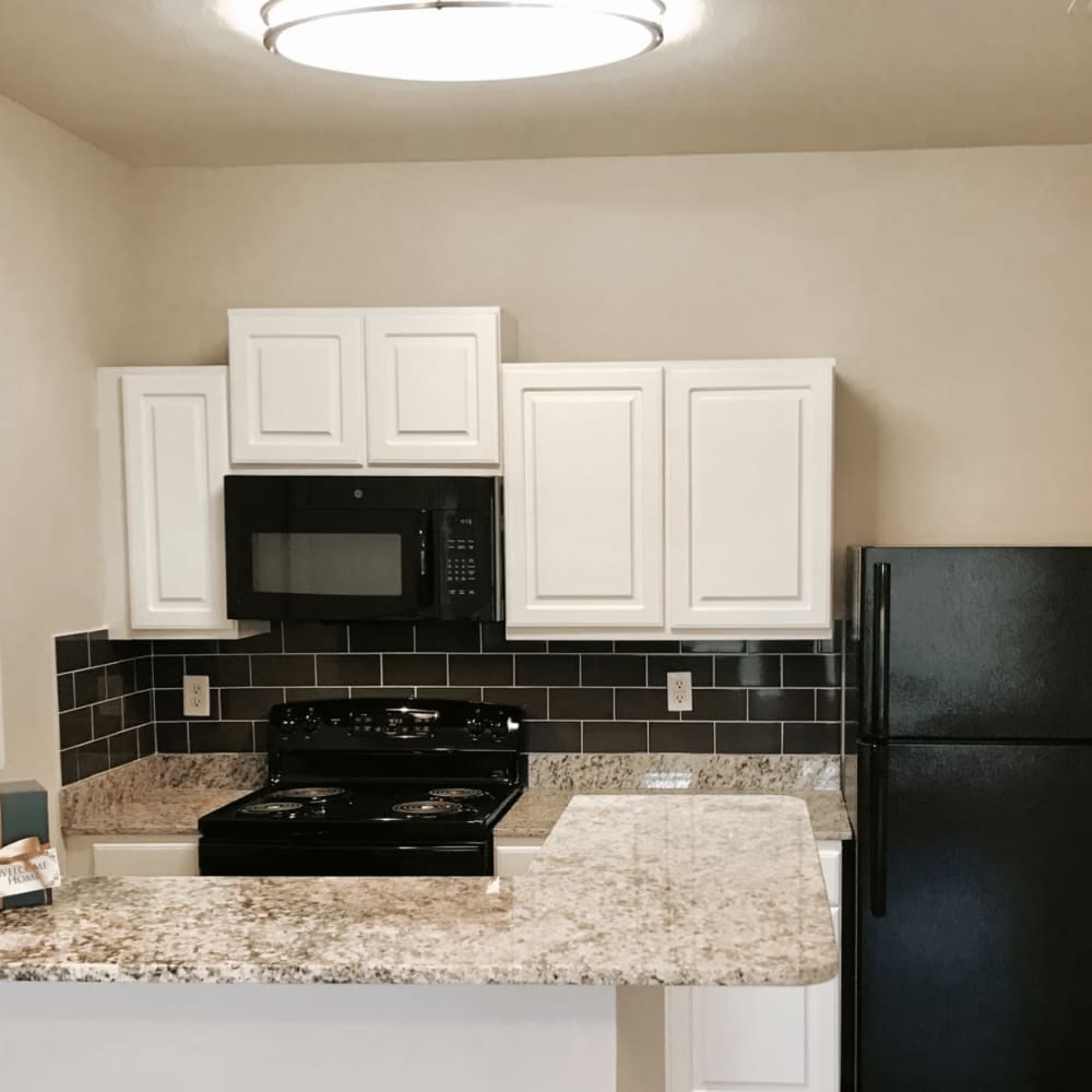 Kitchen with granite countertops and appliances at Dominion Park in San Antonio, Texas