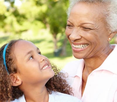 Resident and grandchild smiling outside at The Commons at Woodland Hills in Woodland Hills, California