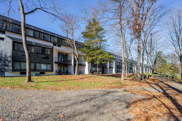 Exterior view of apartment building and outdoor walking path at Whitewood Pond Apartments in North Haven, Connecticut