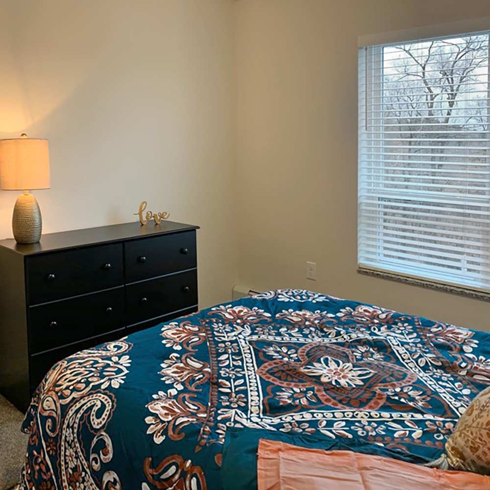 Spacious bedroom with large bed, large window and carpet flooring at Depot on Main in Zimmerman, Minnesota