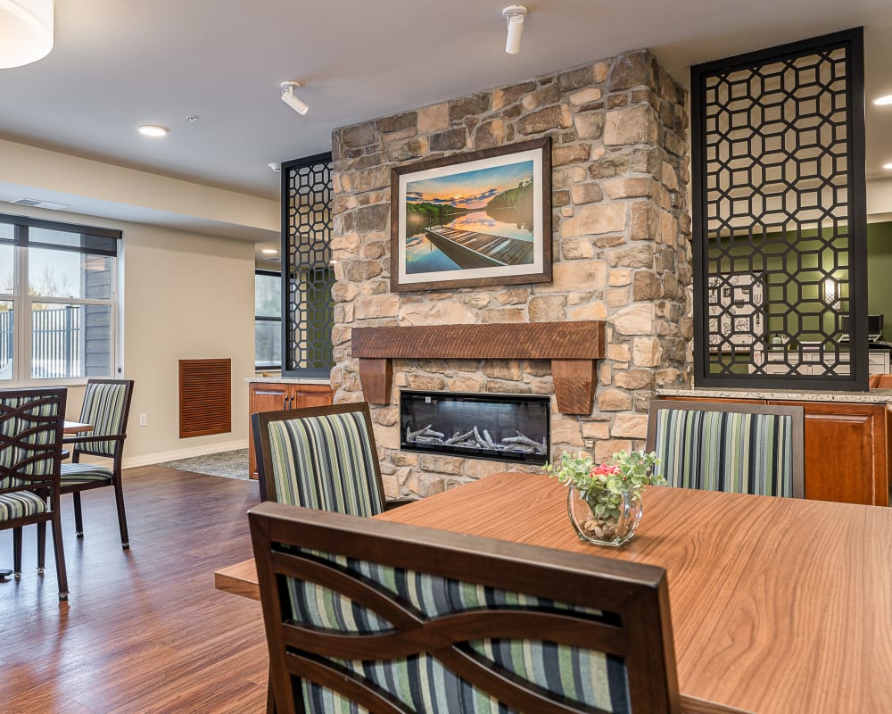 Resident dining hall with stone fireplace at The Pillars of Hermantown in Hermantown, Minnesota
