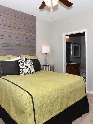 Elegant model master bedroom with carpet style flooring and a ceiling fan at Outlook Ridge in Pueblo, Colorado