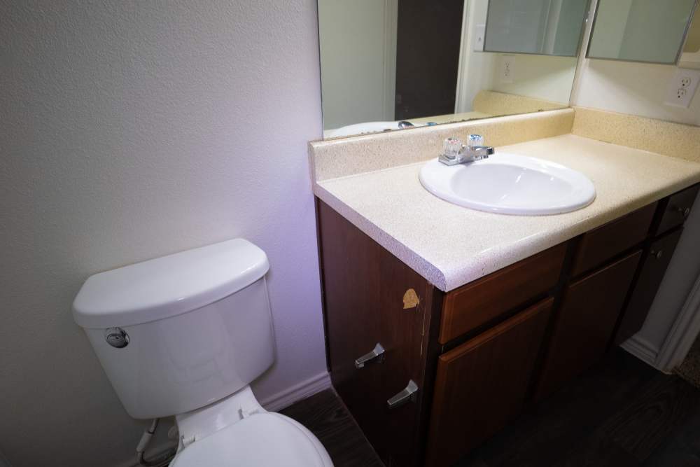 Bathroom with sink and commode at Timber Village II in Marshall, Texas