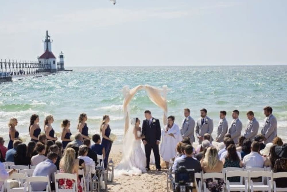 Couple at their wedding ceremony with friends and family at The Whitcomb Senior Living Tower in St. Joseph, Michigan