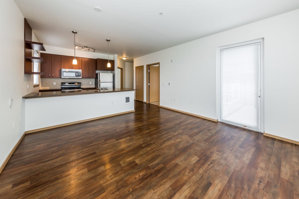 Living room and kitchen with wood style flooring at Marq West Seattle in Seattle, Washington