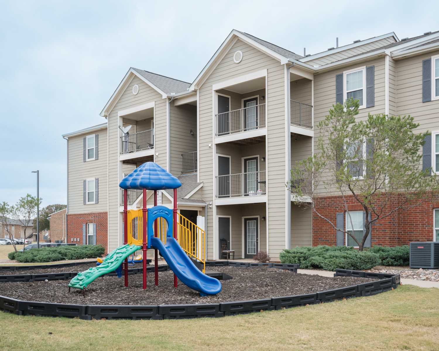 Charming playground and inviting balconies at Cascade Villas in Wichita Falls, Texas.