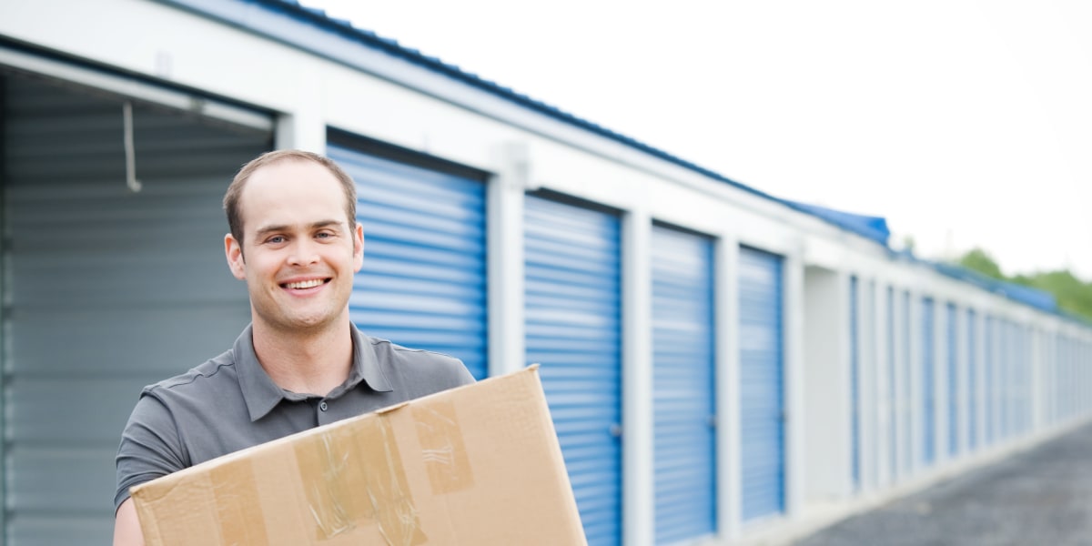 A man with a box in front of a unit at I-205 Mini Storage in Vancouver, Washington