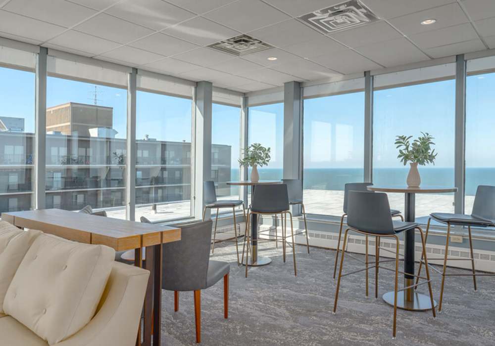Clubhouse dining area with table, chairs and large windows at 12000 Edgewater in Lakewood, Ohio