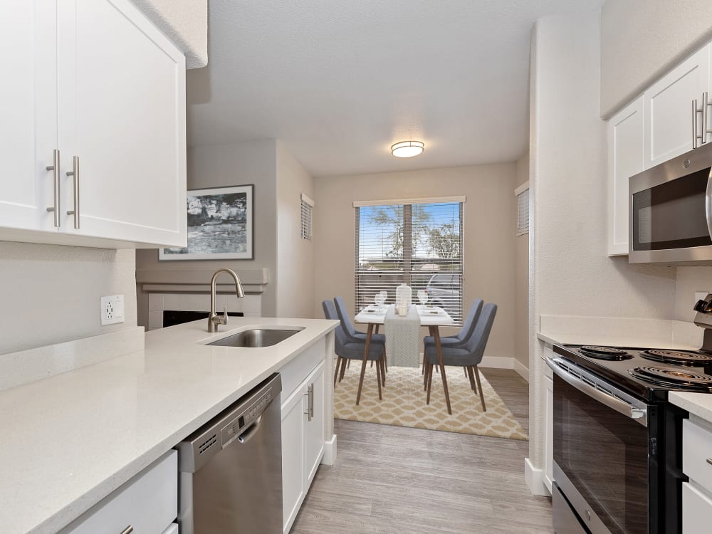Kitchen with modern appliances and dining room with dining set at The Retreat Apartments in Phoenix, AZ