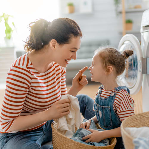 A mother and daughter doing laundry together in a home at Canyon View in San Diego, California