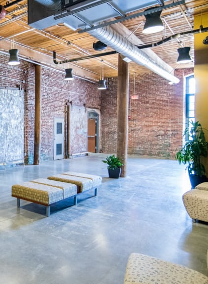 Tall ceiling and open format fitness center features treadmills, free weight, rope wall, hanging rings and more at Loray Mill Lofts in Gastonia, North Carolina