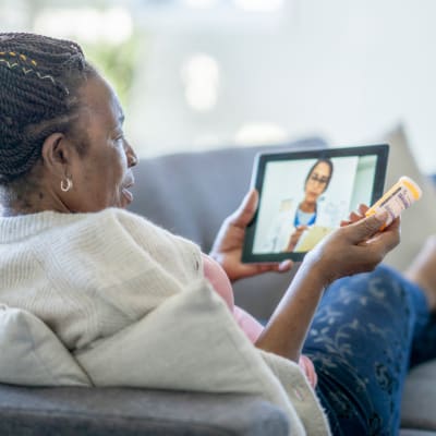 Resident discussing her care plan with a doctor via teleconference on a tablet device at Cascade Park Vista Assisted Living in Tacoma, Washington