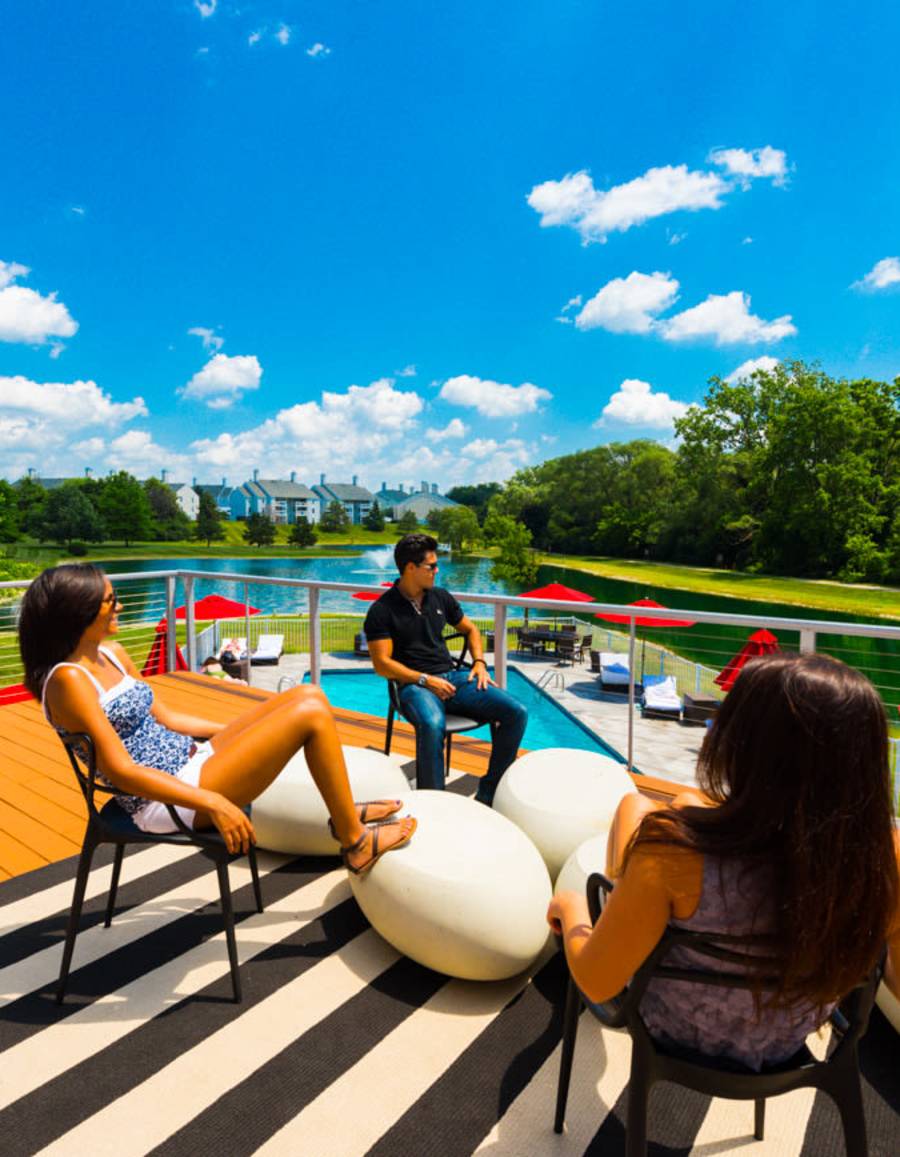 Friends hanging out on the patio overlooking the pool at Woodland Mews in Ann Arbor, Michigan 