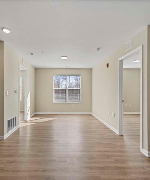 Spacious open layout with wood-style flooring and natural light from large windows at Edison Crossing in Mount Clemens, Michigan