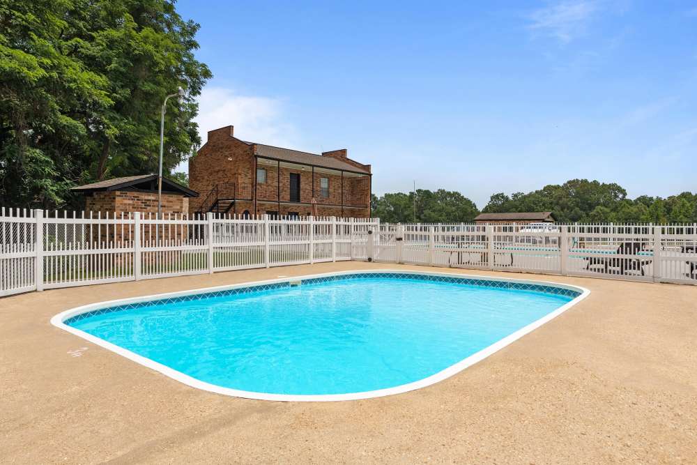 Sparkling water pool surrounded by lush landscaping at Pecan Ridge in Vicksburg, Mississippi.