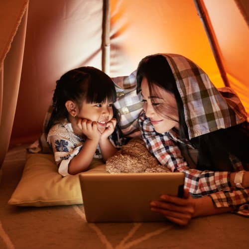 Mother and daughter under the covers reading at Winsted at Sunset West in Rocklin, California