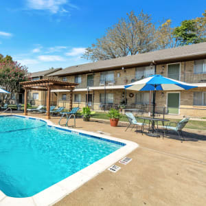 Resident swimming pool and pool deck seating at Franciscan Apartments in Garland, Texas