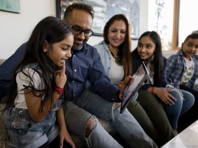 Family on the couch at Sycamore Commons Apartments in Fremont, California