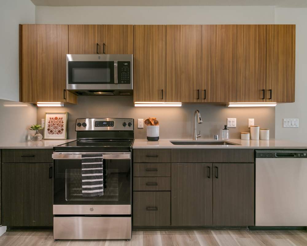 Comfortably decorated kitchen with wooden cabinets in a model home at Olympus Latitude in Albuquerque, New Mexico