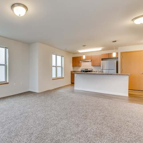 Spacious living room with connecting kitchen at Fox Crossing Apartments in Burlington, Wisconsin