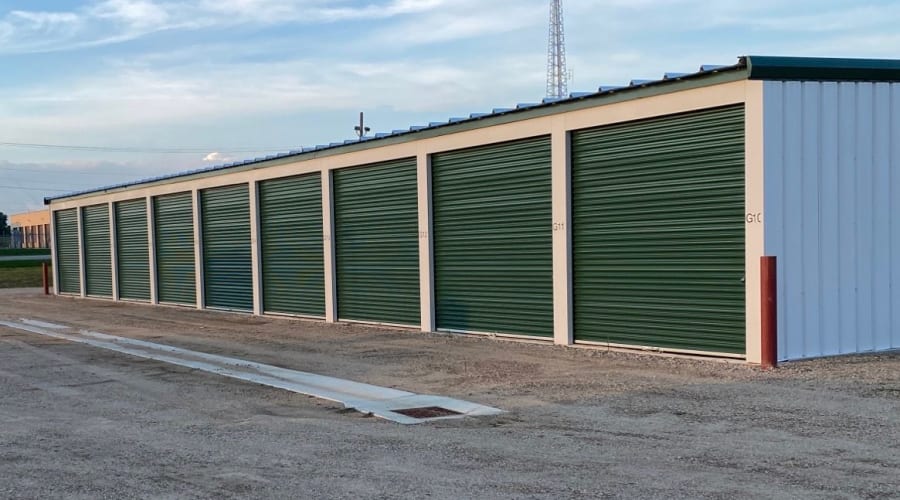 Outdoor storage units with green doors and trees in the background at KO Storage in Willmar, Minnesota