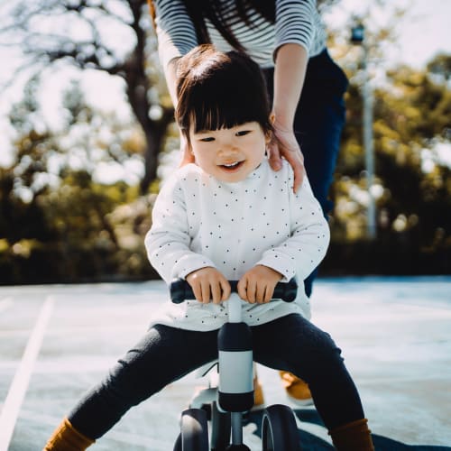 A mother helping her daughter ride a bike at Serra Mesa in Oceanside, California