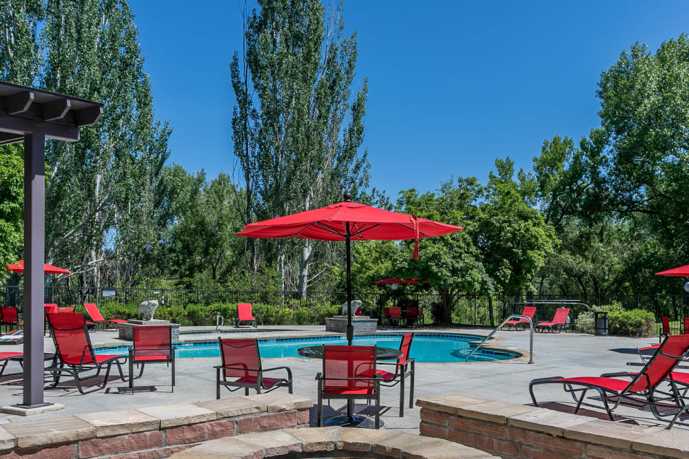 Beautiful resort-style swimming pool with lounge chairs at The Crossings at Bear Creek Apartments in Lakewood, Colorado