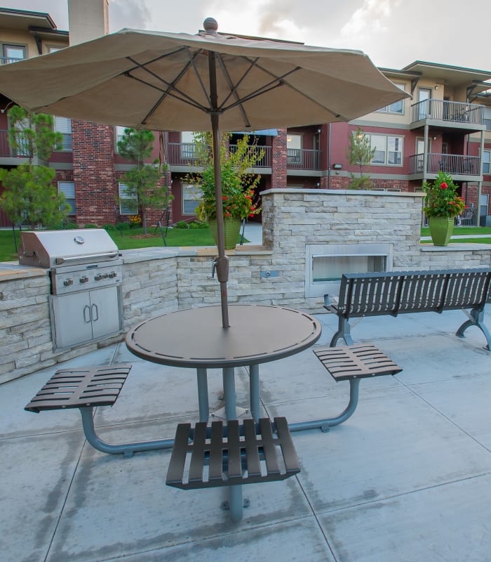 Outdoor umbrella seating with bbq at The Reserve at Elm in Jenks, Oklahoma