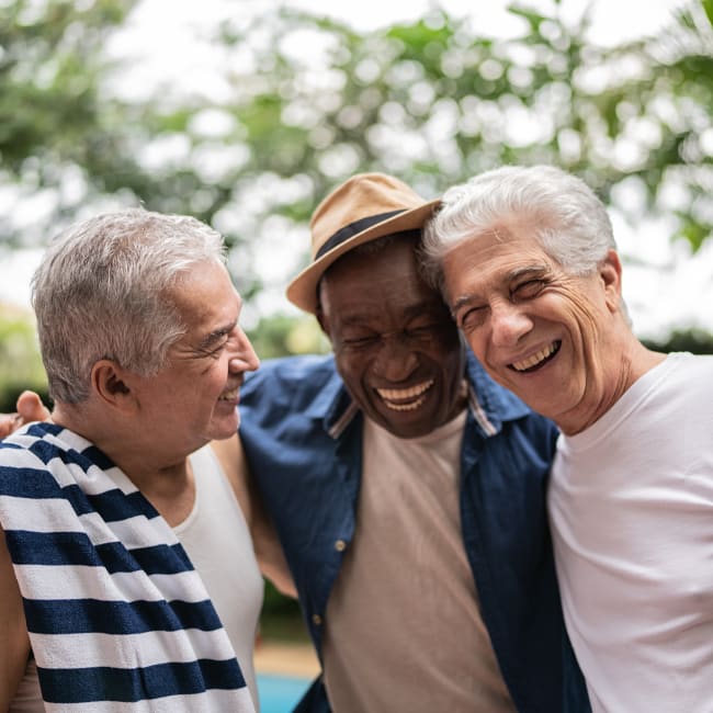 Trio of senior men laughing outdoors at Pillars Senior Living in Lakeville, Minnesota