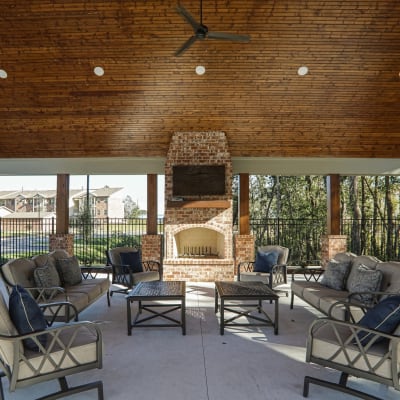 Covered outdoor area with fireplace at La Maison Of Saraland in Saraland, Alabama