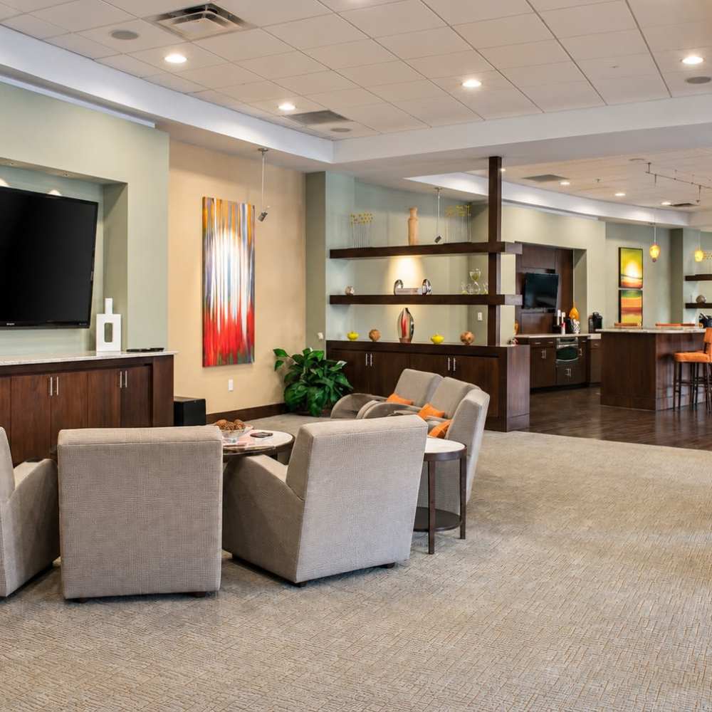 Seating area and kitchen in the clubhouse at Crescent Centre Apartments & Townhomes in Louisville, Kentucky