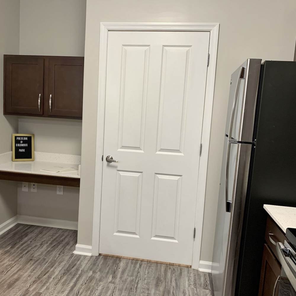 Kitchen with refrigerator and storage door at Preserve At Columbus Park in Columbus, Georgia