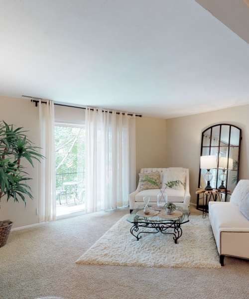 Living room with carpet flooring at Beau Jardin Apartments in St. Louis, Missouri