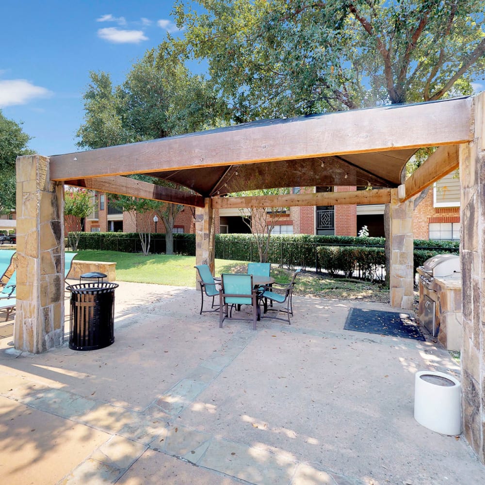 Covered barbecue area with gas grills at Oaks Riverchase in Coppell, Texas