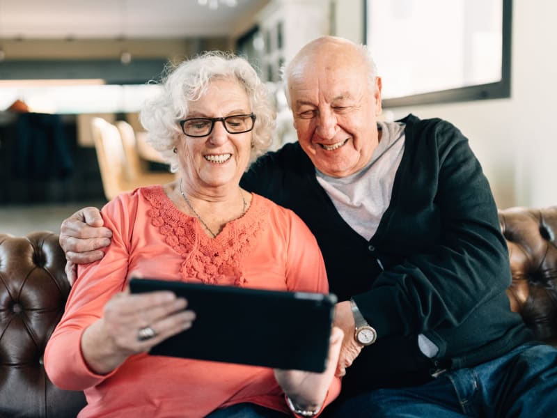 Resident couple smiling while on a video-call at a WISH community