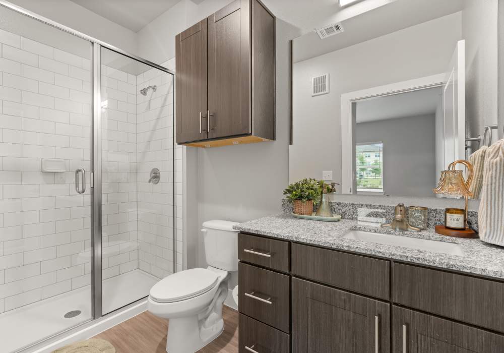 Bright bathroom with glass sliding doors at The Janson in Del Valle,  Texas